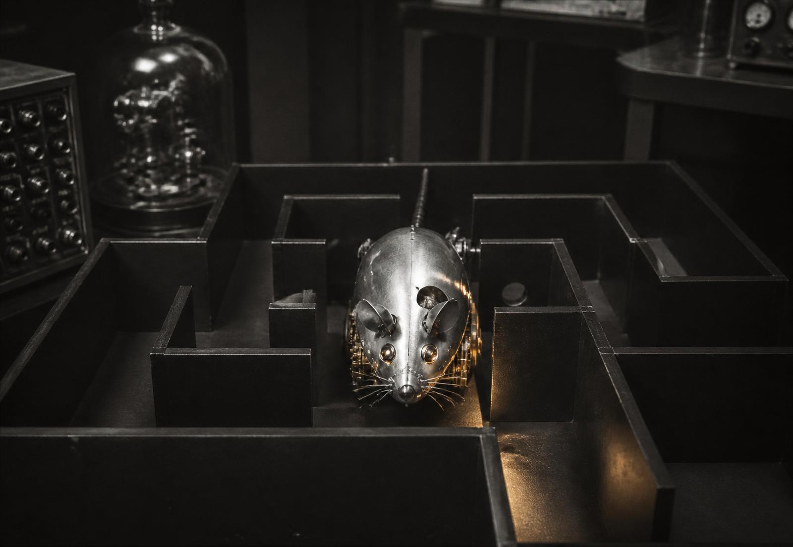 A metallic mechanical mouse navigating a dark laboratory maze